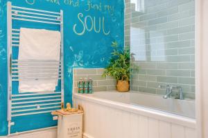 a bath tub in a bathroom with a blue wall at 3 Bed in Wotton-under-Edge oc-l33488 in Wotton under Edge +27 photos
