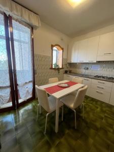 a kitchen with a table and white cabinets and a table and chairs at B&B L'Orchidea in Pisa