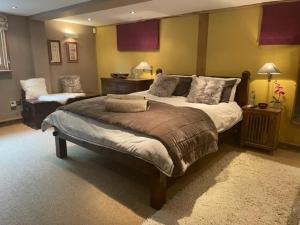 a large bedroom with a large bed and a table at The Lodge, Smarden in Smarden