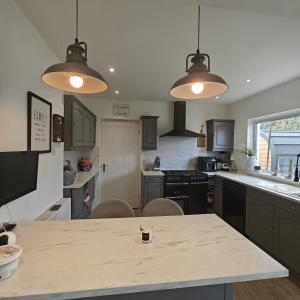 a kitchen with a table and two lights at 3 Bed in Pentlepoir oc-a33527 in Kilgetty +4 photos