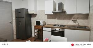 eine Küche mit Kühlschrank und Herd Oberer Backofen in der Unterkunft Billotti in Biella