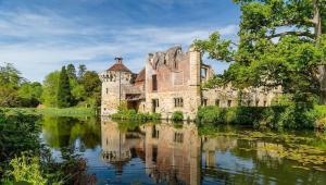 an old castle with its reflection in a lake at The Lodge, Smarden in Smarden