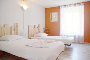 a room with two beds and a window at Le Bourgneuf in Chartres +9 photos