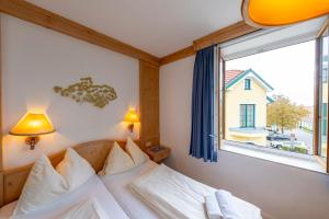 a bedroom with a bed and a large window at Hotel Krug in Gumpoldskirchen