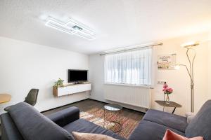 Una sala de estar con un sofá y un televisor. en Die Schneiderei, en Balingen