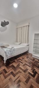 a bedroom with a bed and a wooden floor at Centro de Florianópolis praça XV in Florianópolis