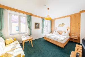ein Hotelzimmer mit zwei Betten und einer Couch in der Unterkunft Hotel Krug in Gumpoldskirchen + 45 Fotos