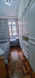a bedroom with two beds and a wooden floor at Centro de Florianópolis praça XV in Florianópolis +4 photos