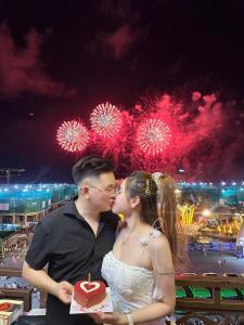 a man and woman kissing with a cake with fireworks at The Little Leaf Hostel - Restaurant & Rooptop Bar in Cat Ba