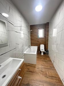a bathroom with a white tub and a toilet at Apartament panoramic in Bistriţa