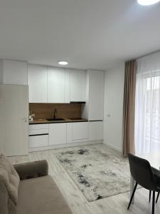a living room with a table and a kitchen at Apartament panoramic in Bistriţa