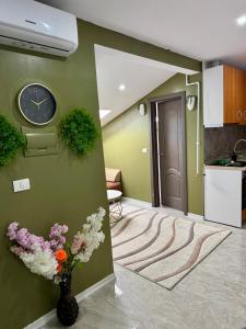 a room with a clock and flowers on a wall at Cozy Apartament with 2Rooms in Timişoara