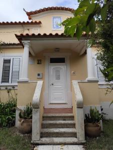 a house with a white door and stairs at Casa da Nogueira in Alvorninha +24 photos