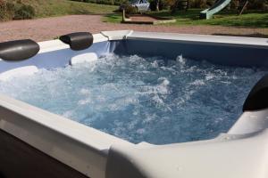 a hot tub with water in it in a yard at VillaNonna, jacuzzi, billards, pétanque, ping-pong, 12 couchages, terrasse plein soleil - Larès in Saint Remy sur Orne