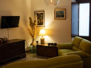 een woonkamer met een bank en een televisie bij Gran Caffè Bed in Castrovillari