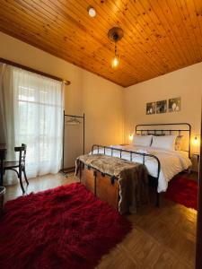 a bedroom with a bed and a wooden ceiling at Forrest Guesthouse in Polídhroson