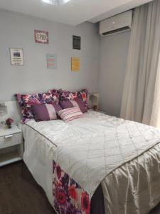 a bedroom with a large bed with pillows on it at Apartamento aconchegante 10 minutos de Penedo in Resende