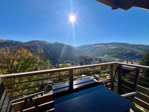 a table on a balcony with a view of the mountains at Superbe appartement neuf avec Sauna privé & Terrasse vue sur la montagne in La Bresse