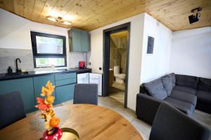 a kitchen and living room with a table and a couch at A Frame Chalet By Superski in Cavnic