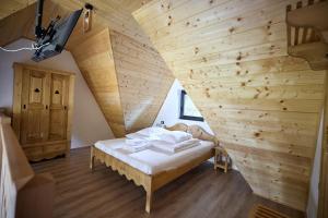 a room with a bed in a wooden wall at A Frame Chalet By Superski in Cavnic
