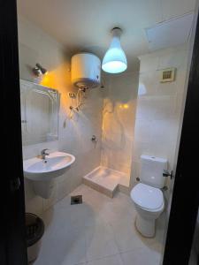 a bathroom with a sink and a toilet and a light at Porto Sokhna Pyramids Hotel Apartments in Ain Sokhna