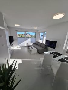 a white living room with a couch and chairs at Haus am Wittenwiewerbarg in Dahme