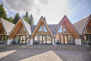 an exterior view of a building with large windows at A Frame Chalet By Superski in Cavnic +7 photos