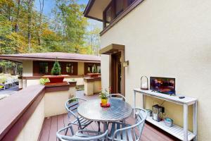 a patio with a table and chairs on a deck at The Frank Lloyd Wright Home @ Deep Creek, MD in Bittinger