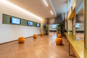 an empty lobby with orange stools in a room at Best Western Madison Hotel in Milan
