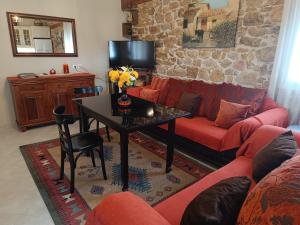 a living room with a couch and a table at Grandmas Cottage in Ávdhira