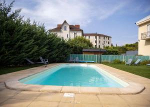 a swimming pool in the backyard of a house at Les Ambassadeurs Logis Hotels et Restaurant in Souillac