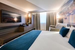 una habitación de hotel con una cama grande y un sofá en Novotel Paris Centre Bercy, en París