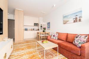 a living room with a couch and a table at Your Holidays Komfortowy Apartament Bel Mare 213 F, Parking Gratis in Międzyzdroje