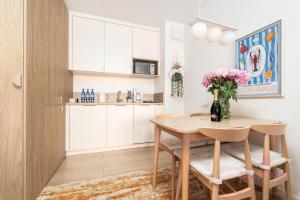 a kitchen with a table and a vase of flowers at Your Holidays Komfortowy Apartament Bel Mare 213 F, Parking Gratis in Międzyzdroje +8 photos