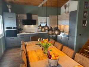 a kitchen with a wooden table with a bowl of fruit at Blockhaus am Edersee in Vöhl