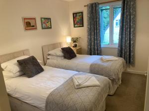 two twin beds in a room with a window at Sue's Lodge in Cawsand