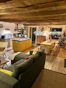 a living room with a couch and a kitchen at Gîte 8 pers avec jacuzzi et jardin Aurillac in Arpajon-sur-Cère