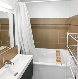 a bathroom with a white tub and a white sink at Un Temps Pour Nous - Downtown house near beach in Cucq