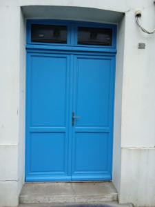une porte bleue sur le côté d'un bâtiment dans l'établissement LE GOELAND, à Ault