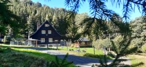 a large brown house in front of a mountain at Leśniczówka w Dolinie in Świeradów-Zdrój