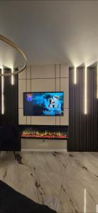 ein Wohnzimmer mit einem großen TV und einem Kamin in der Unterkunft Hanza King Apartament 1 and SPA in Stettin