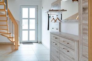 a kitchen with wooden cabinets and a staircase at Ferienhaus Rerik Piratenlager in Rerik