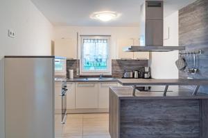 a kitchen with a refrigerator and a sink at Ferienhaus Rerik Piratenlager in Rerik +17 photos