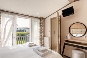a bedroom with a bed and a mirror and a window at 2 Bed in Hendra Croft oc-h32360 in Cubert