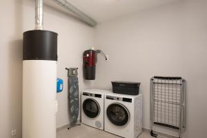 a laundry room with a washer and a washing machine at Villa Joy, moderna e sofisticada in Funchal