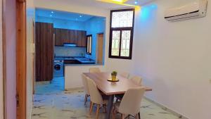 a kitchen and dining room with a wooden table and chairs at Appartement Aéroport Sunset Marrakech in Marrakesh