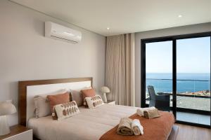 a bedroom with a large bed with a view of the ocean at Villa Joy, moderna e sofisticada in Funchal