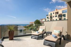 two chairs on a balcony with a view of the ocean at Villa Joy, moderna e sofisticada in Funchal
