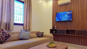a living room with a couch and a tv at Appartement Aéroport Sunset Marrakech in Marrakesh