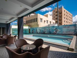 a view of a pool with chairs and a table at GUIDE HOTEL Kenting Resort in Hengchun South Gate